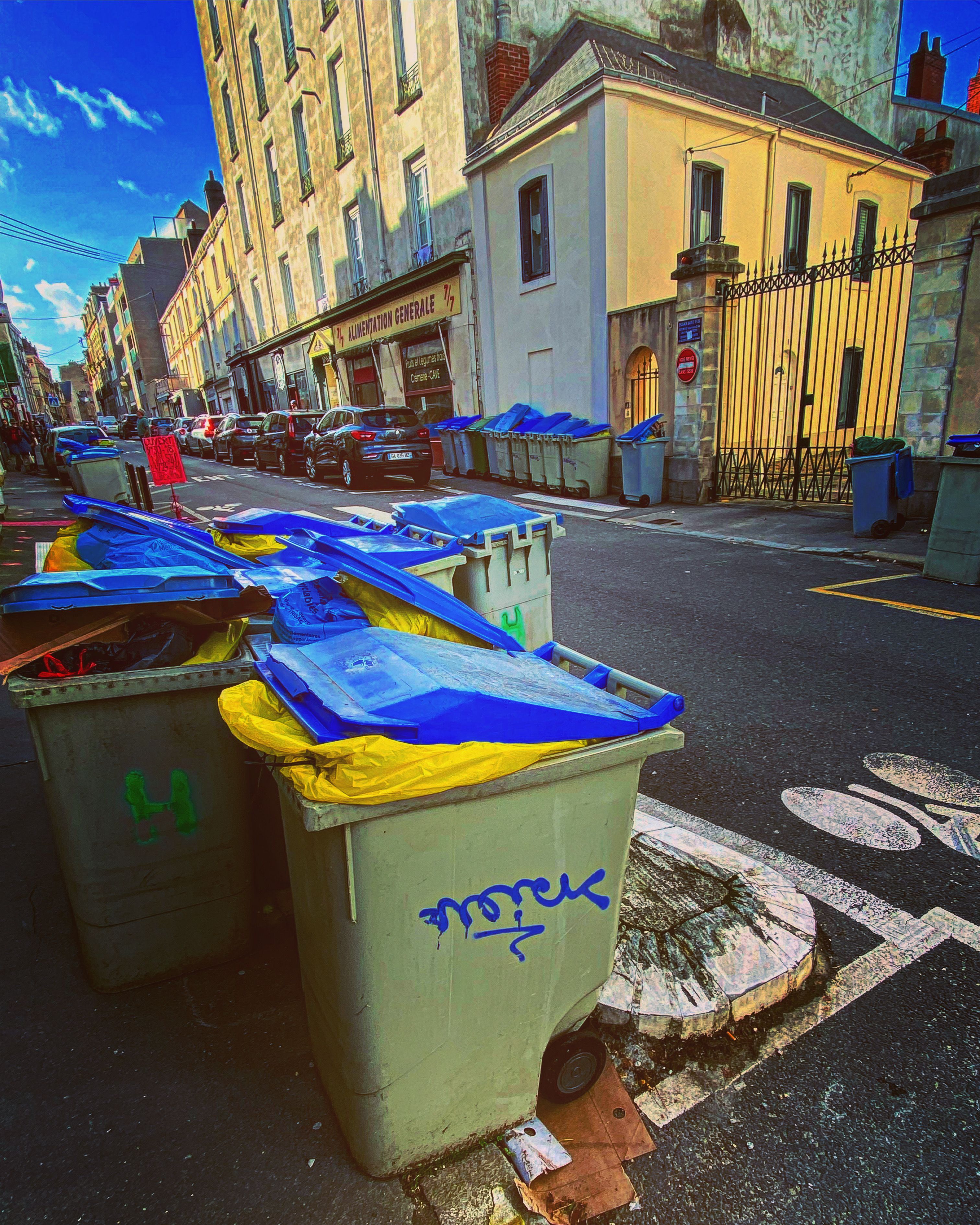 A row of trash cans on a street

Description automatically generated